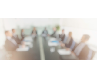 An out of focus photo of people in a meeting.